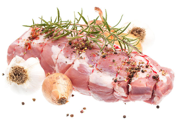A tied up lamb roast with numerous spices, garlic cloves, whole shallots, and two twigs of rosemary